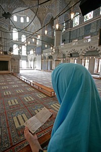 Muslim woman praying at the Blue Mosque in Turkey