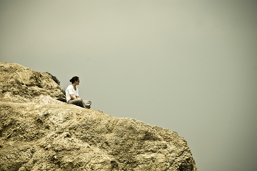 Lonely lady sitting on a rock