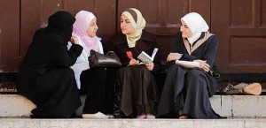 Young Syrian women talking in mosque courtyard