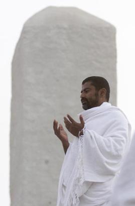 A Muslim pilgrim on the Hajj prays on Jabal al-Rahman