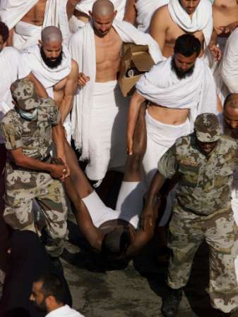 Security personnel and Hajj pilgrims carry a suspected criminal