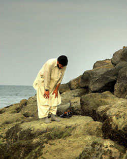 Muslim man praying by the sea